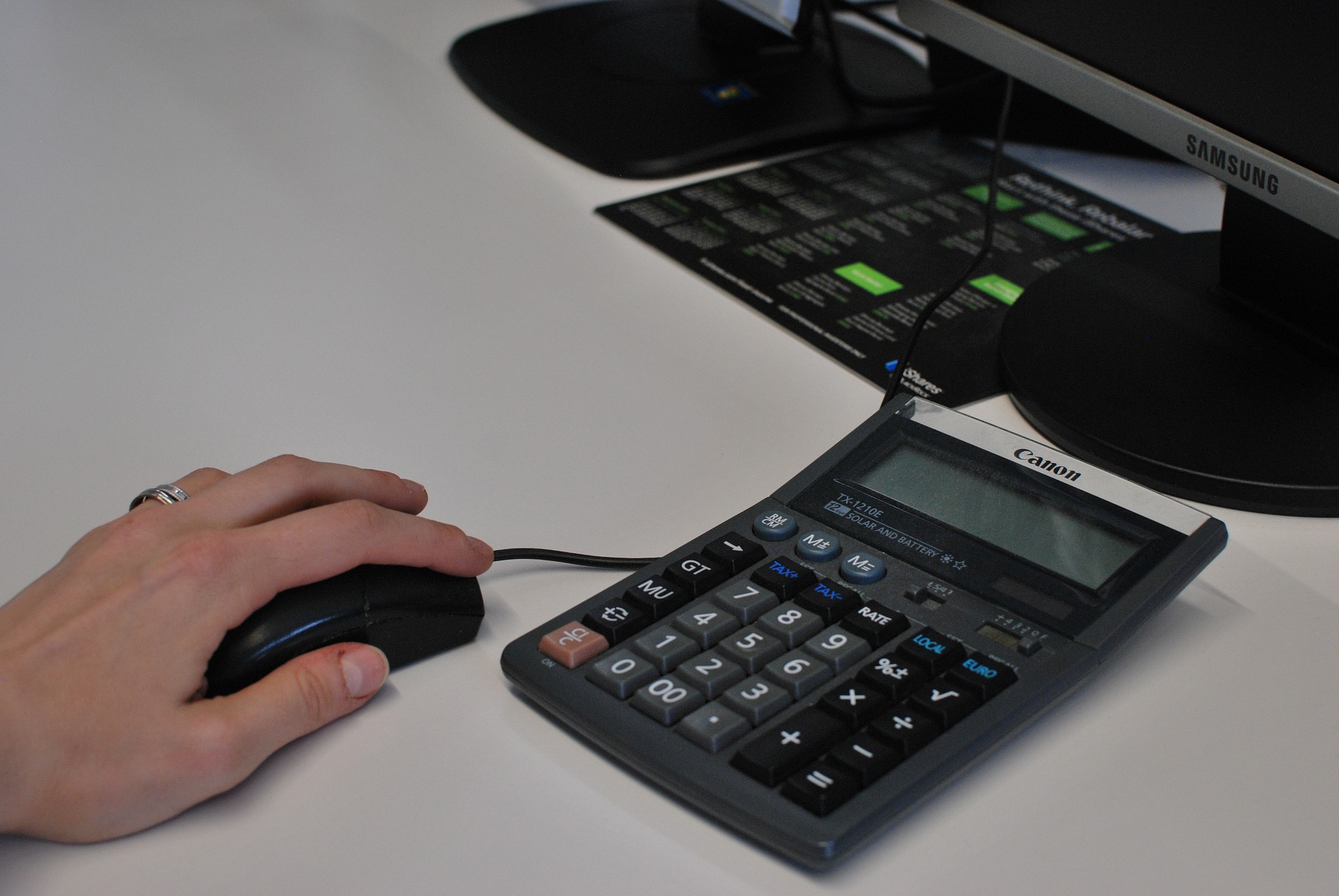 calculator and hand on mouse